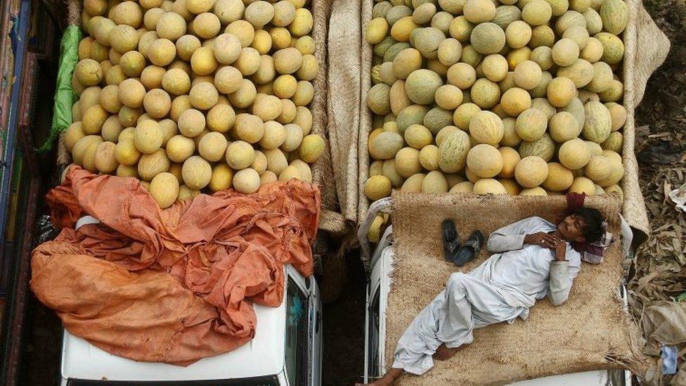 A fruit seller takes a nap at a fruit market in Karachi, Pakistan, 26 May 2017.