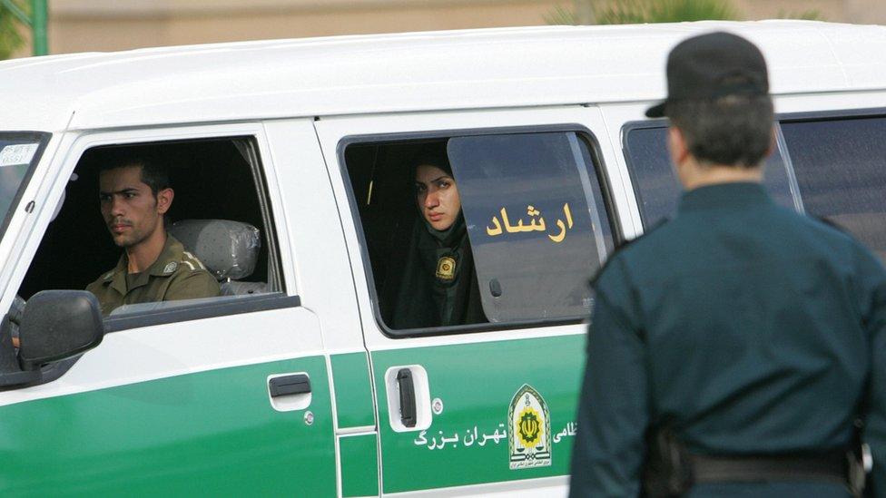 A policewoman looks out of a van of Iran's morality police in Tehran in July 2007