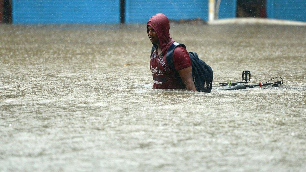 A man wades through flood water in Mumbai