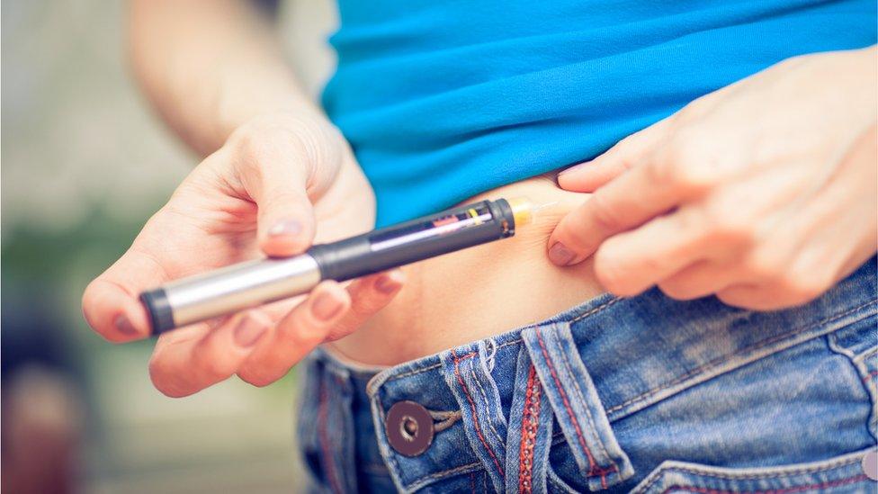 A woman injecting herself with insulin to treat type 1 diabetes