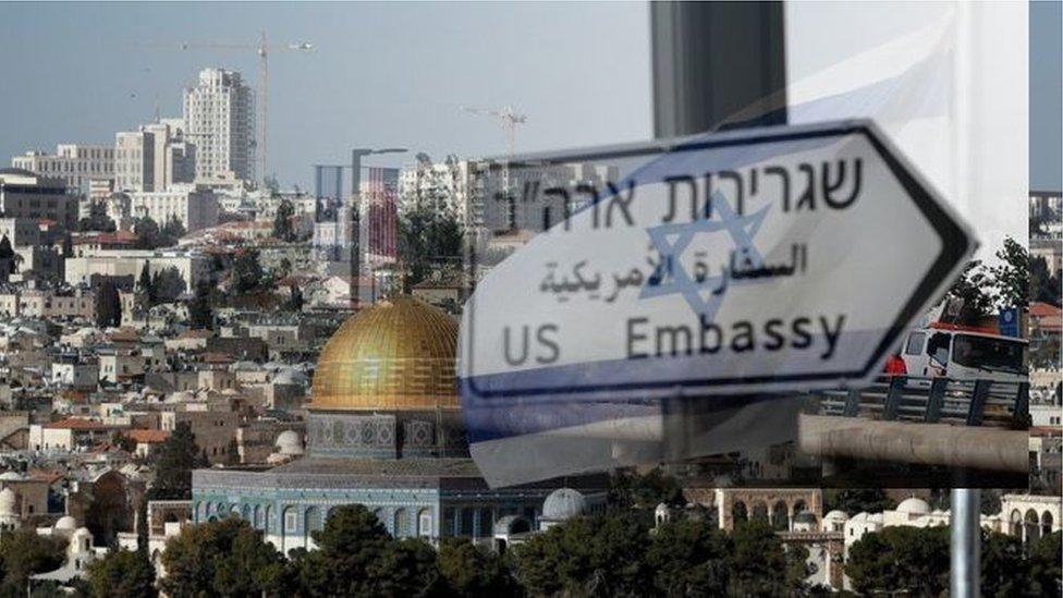 Blended image of the US embassy sign and skyline of Jerusalem