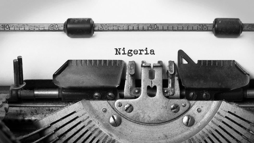 A typewriter with the word Nigeria typed on a piece of paper