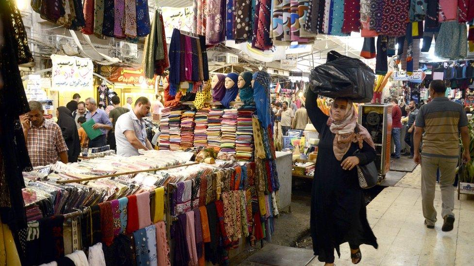 An Iraqi woman walks through a market in eastern Mosul, northern Iraq (14 August 2017)