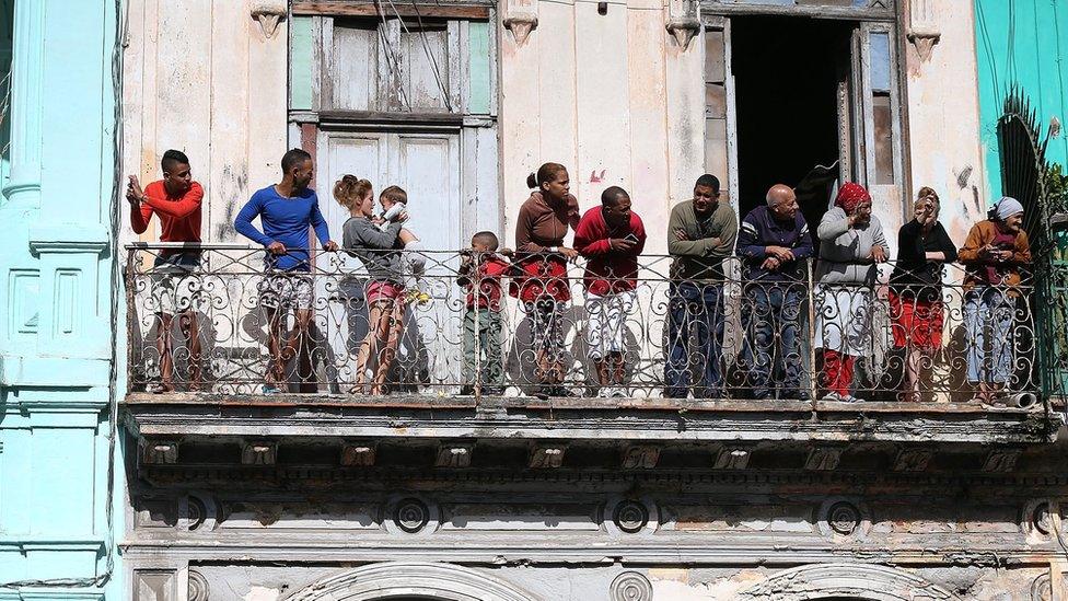 People wait to see U.S. President Barack Obama drive past on his way to address the Cuban people on television from the Gran Teatro on March 22, 2016 in Havana, Cuba