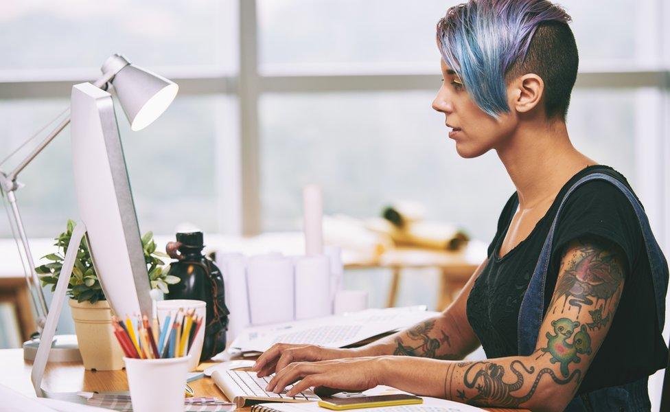 Tattooed woman at a computer