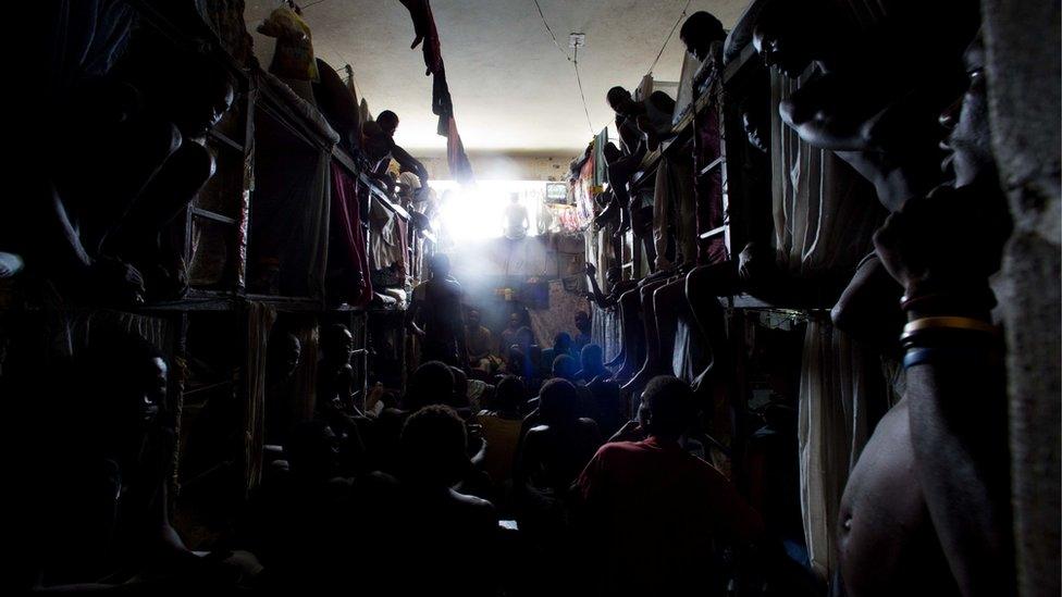 Prisoners cram shoulder to shoulder to watch TV in their crowded cell inside the National Penitentiary in downtown Port-au-Prince