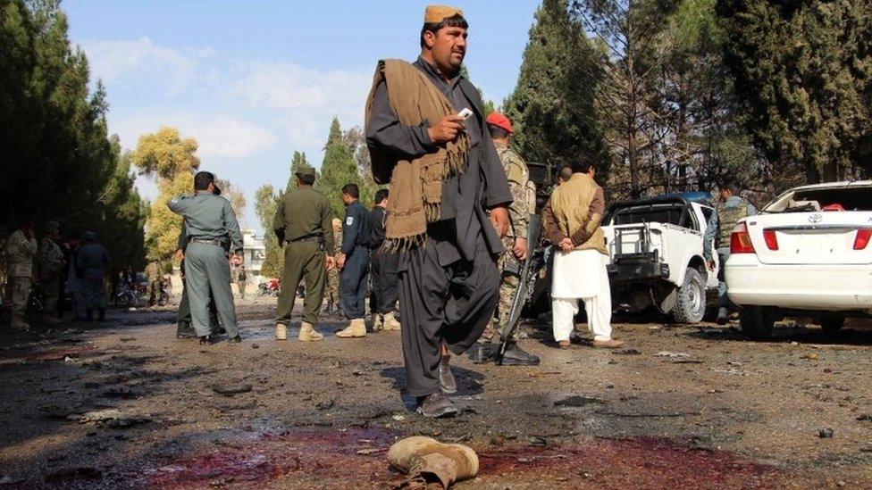 Afghan security officials inspect the scene of a suicide bomb attack that targeted an Afghan Army vehicle in Lashkar Gah, Helmand province (11 February 2017)