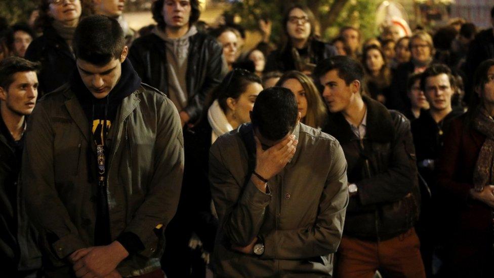 People cry and pray as they look at flames burning the roof of the Notre-Dame Cathedral in Paris, France, 15 April 2019