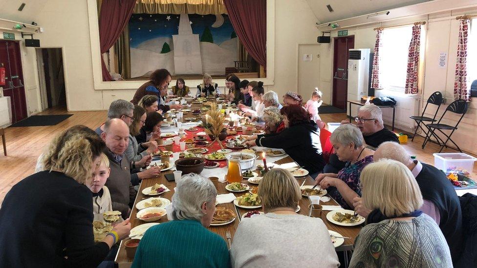 People sitting around a big dinner table