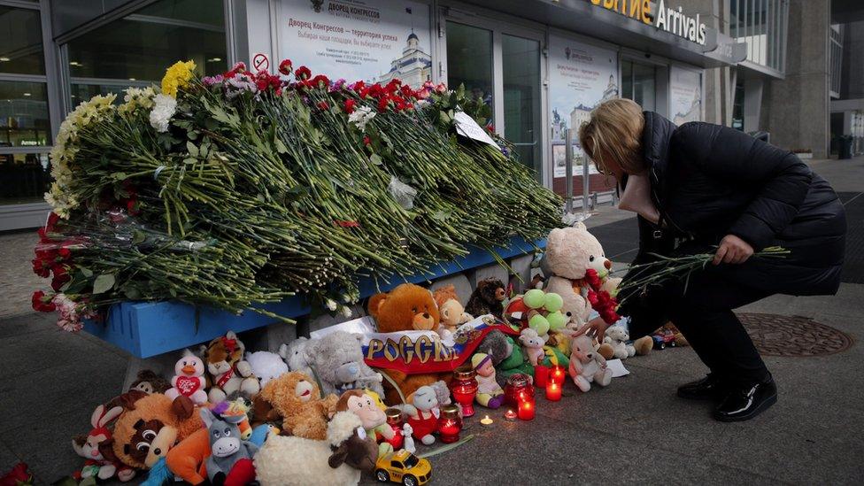 Well-wisher leaves flowers at a tribute to the crash victims at St Petersburg's Pulkovo airport - 1 November