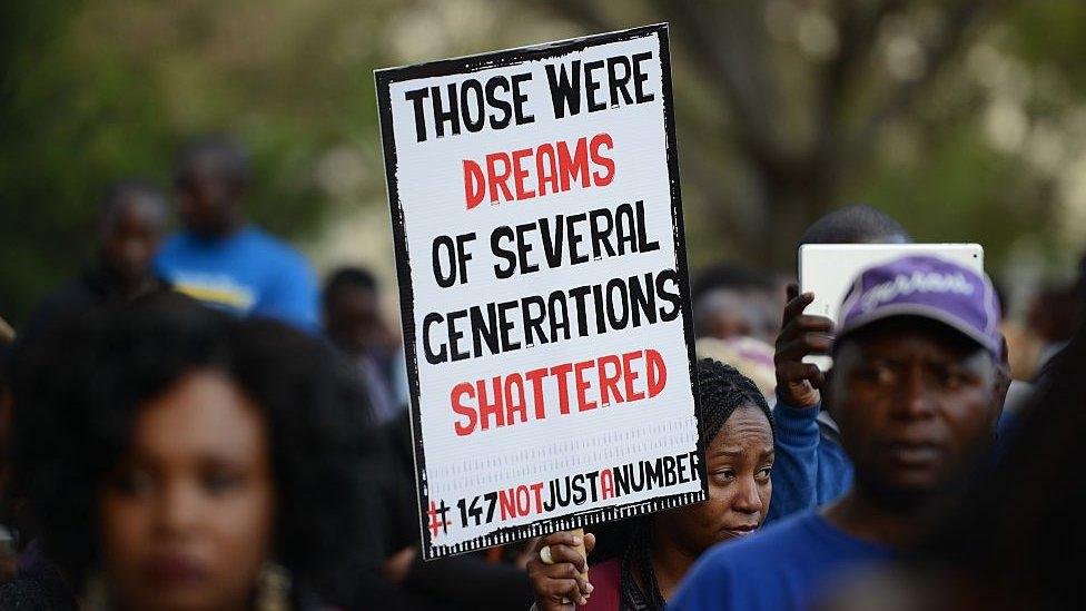 A woman walks with a placard that reads "Those were dreams of several generations shattered"