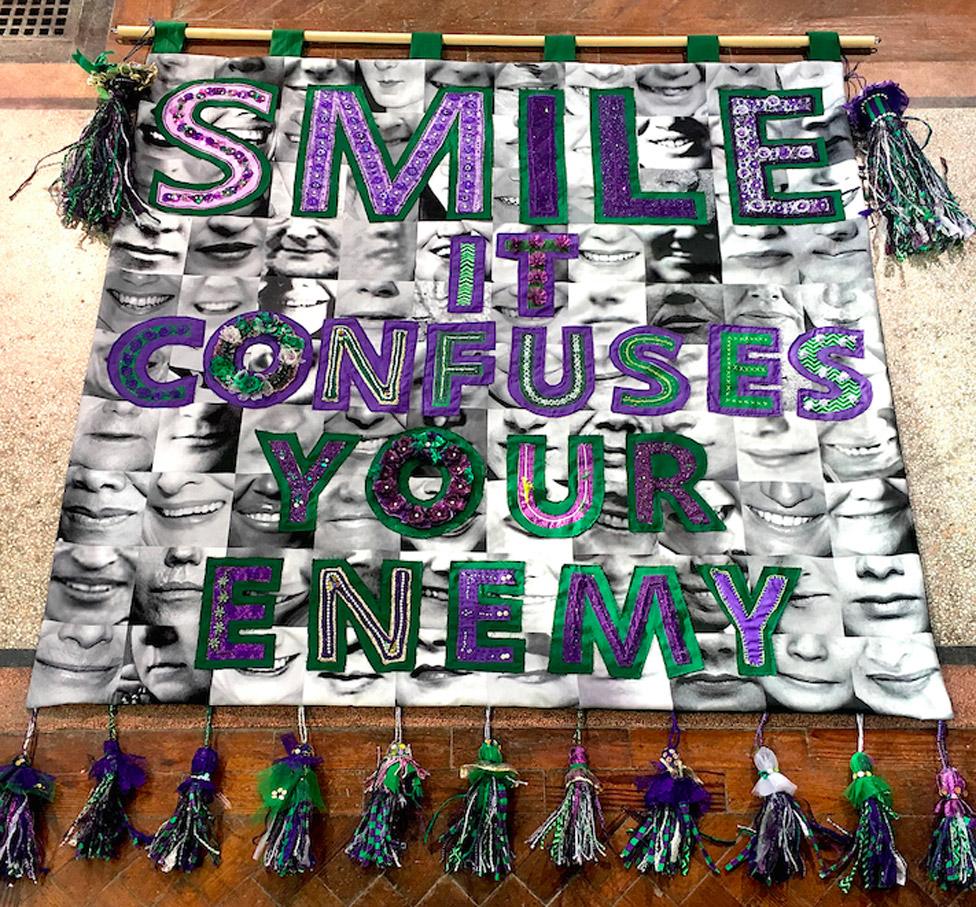 "Smile it confuses your enemy" banner by Junction Arts in Bolsover, Derbyshire, with textile artist Karina Thompson