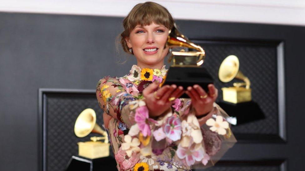 Taylor Swift holding Grammy award