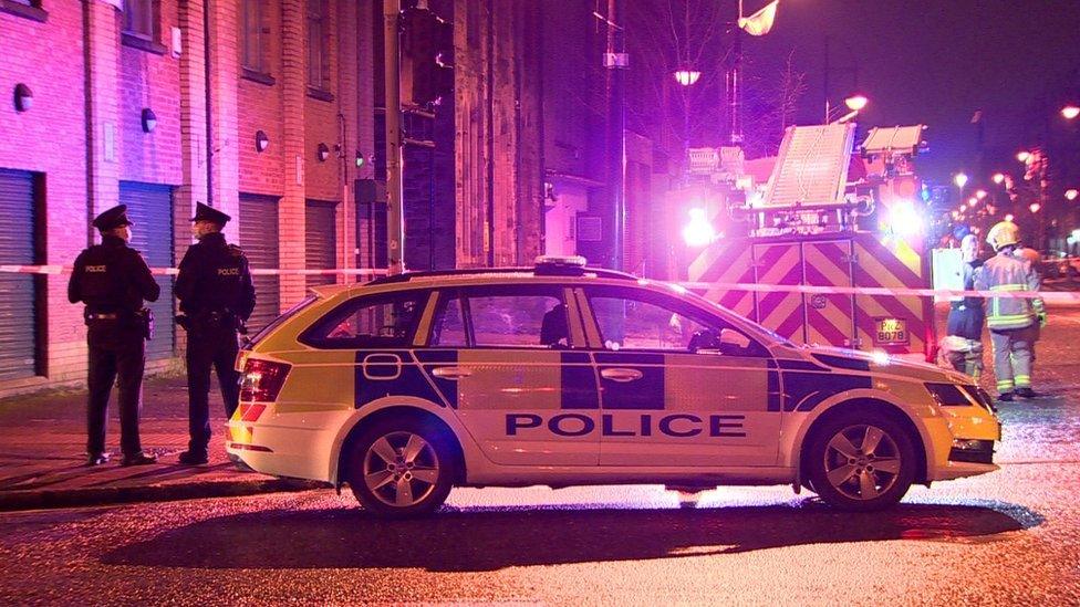 Police officers, a police vehicles, fire fighters and a fire engine at the scene of the fire