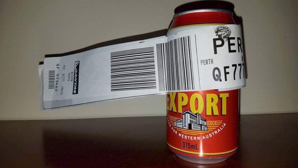 The can wrapped in a Qantas baggage tag