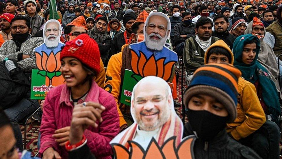 Bhartiya Janata Party (BJP) supporters listen to a speech of India's Home Minister and BJP leader Amit Shah during an election rally in Loni, Ghaziabad district of Uttar Pradesh state on February 3, 2022.