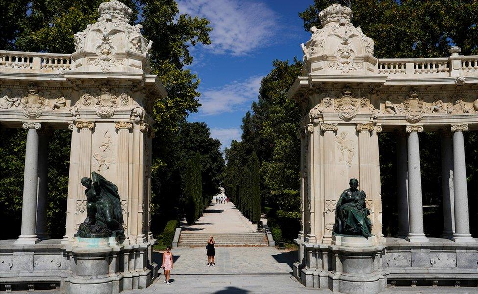 A woman takes pictures at Retiro Park on the day that Unesco added Madrid's historic Paseo del Prado boulevard and Retiro Park to its list of world heritage sites, in Madrid, Spain, 25 July 2021