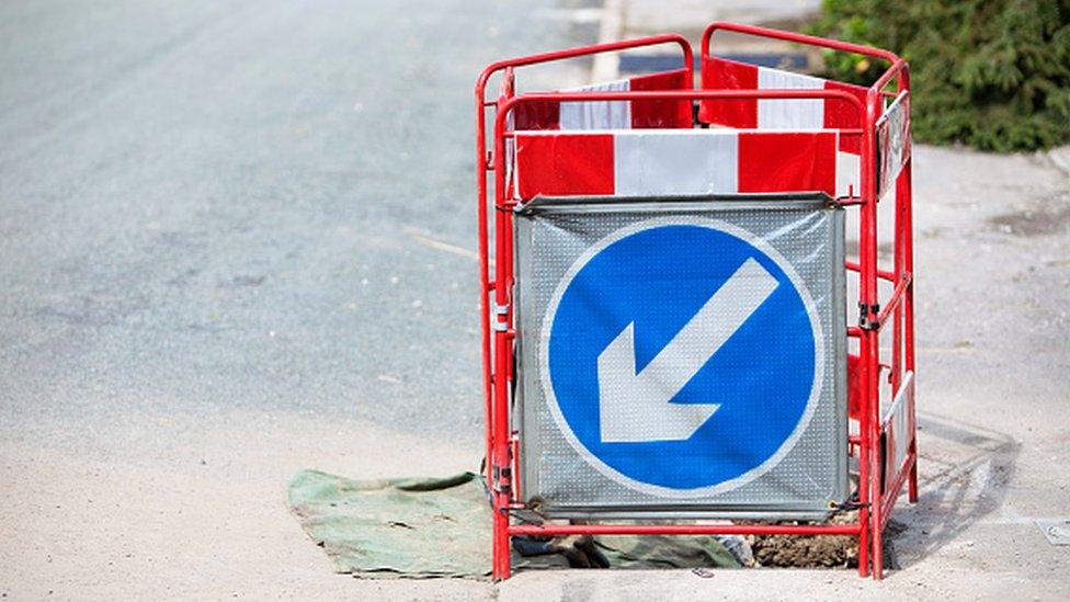 A barrier surrounding a hole in the pavement