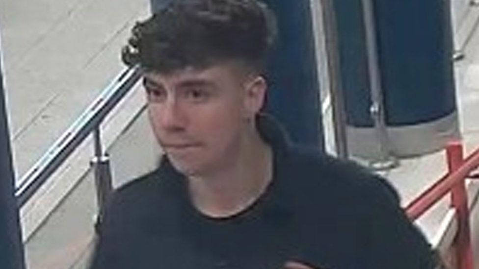 CCTV image of a young man with dark, curly hair at Preston Railway Station