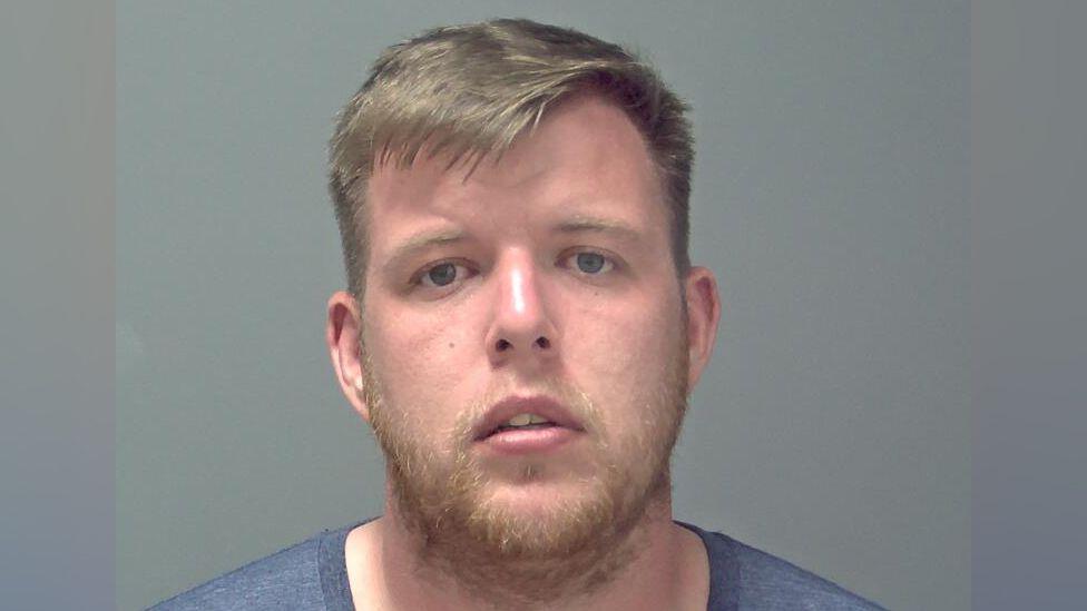Daniel Martin mugshot, he is wearing a blue top with short blonde hair and a blonde beard. 