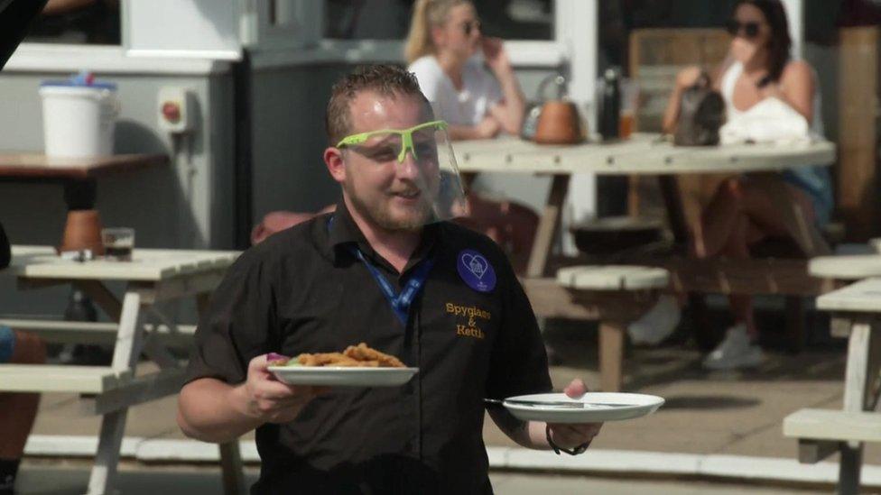 A waiter wearing personal protective equipment