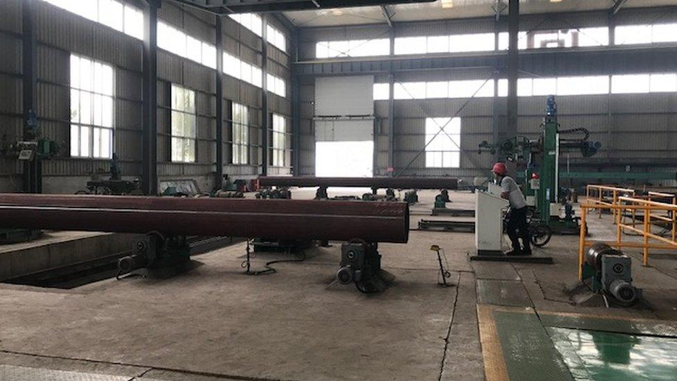 A worker stands in the Hebei Huayang Steel Pipe factory