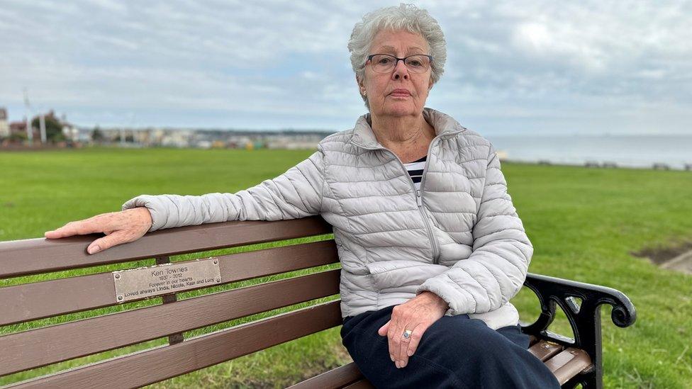 A woman sits on a bench