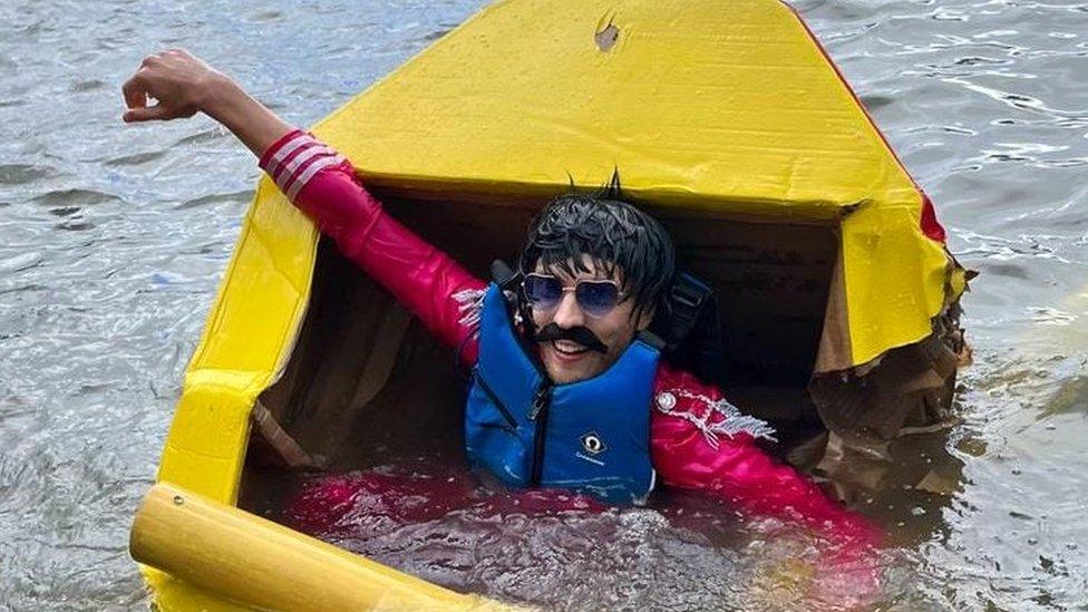 Man in water after cardboard boat race