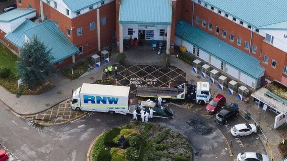 Aerial shot of vehicle removing a taxi that exploded outside a hospital