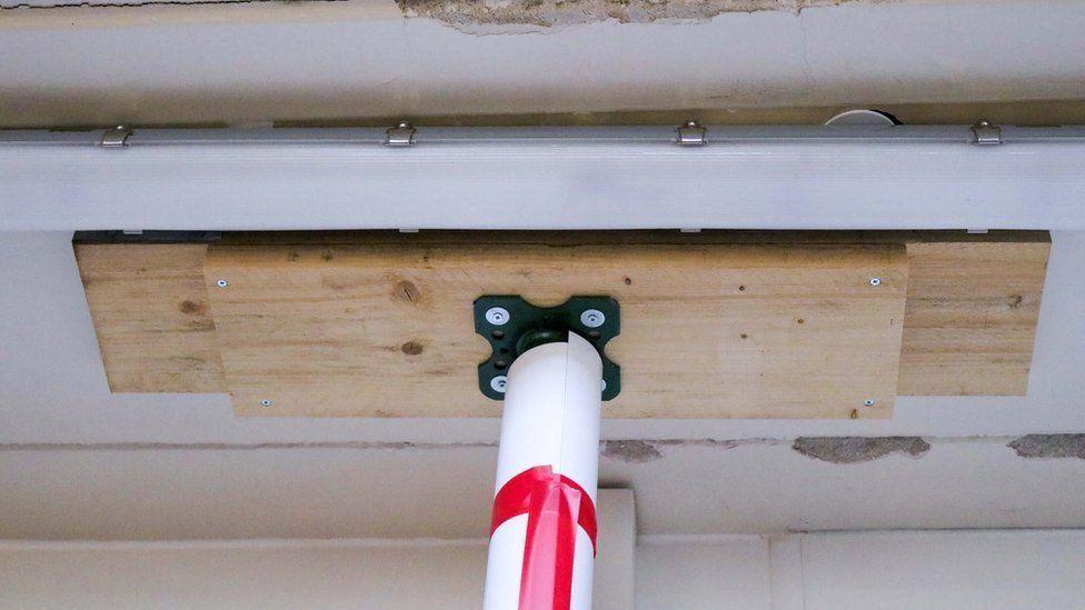 A close up of a prop attached to wooden plank, attached to a ceiling in a hospital.