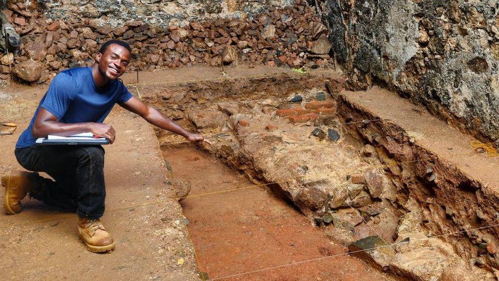 Person pointing at an archaeological site