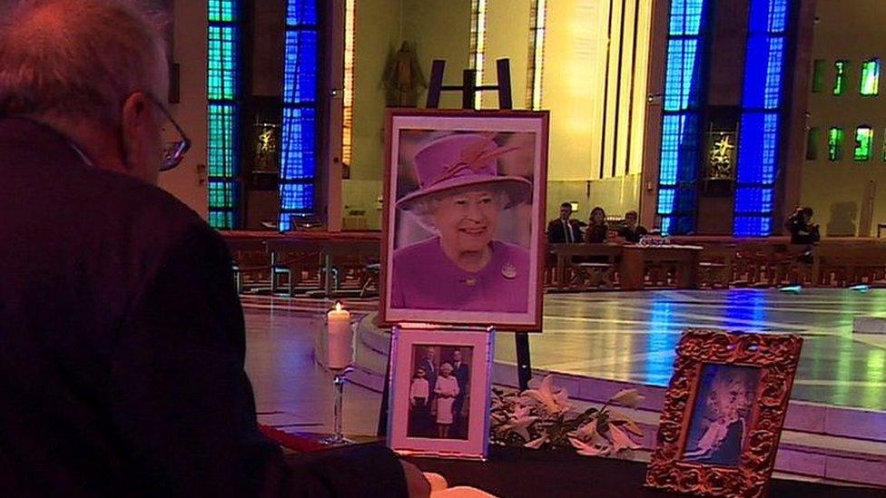 Man signing book of condolence in cathedral