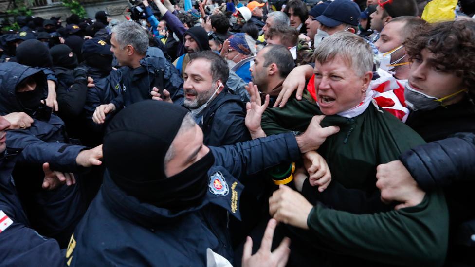 Police in black grab protesters