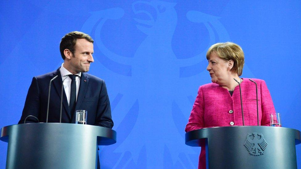 Macron and Merkel sharing a smile during a press conference