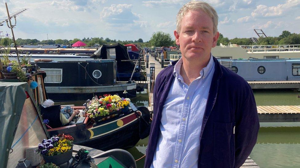 Devizes MP Danny Kruger standing in front of canal boats at Caen Hill Marina