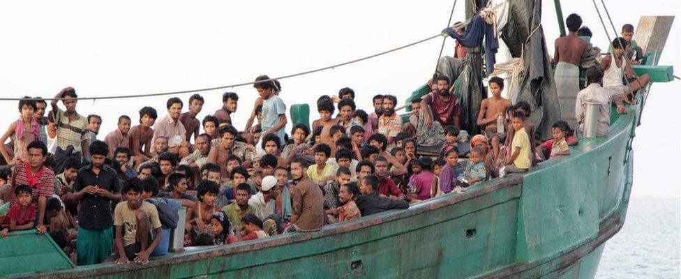 Hundreds of migrants, including Myanmar Rohingya Muslims, sit on their boat as they wait to be rescued by Aceh fishermen off East Aceh, Indonesia. 20 May 2015.