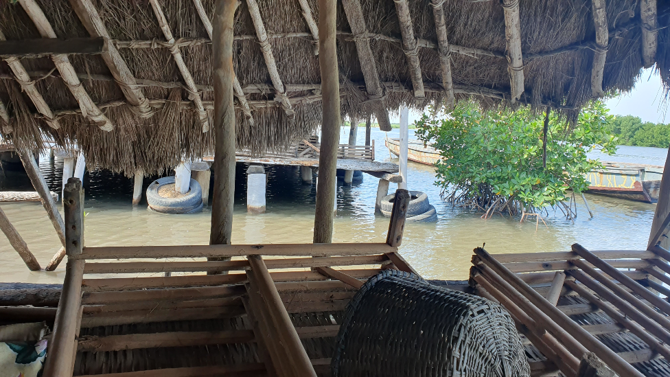 Water seen beneath houses on an island on the Casamance River in Senegal