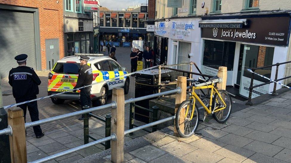 Police officers and police car on White Lion Street, with white police tape around the steps