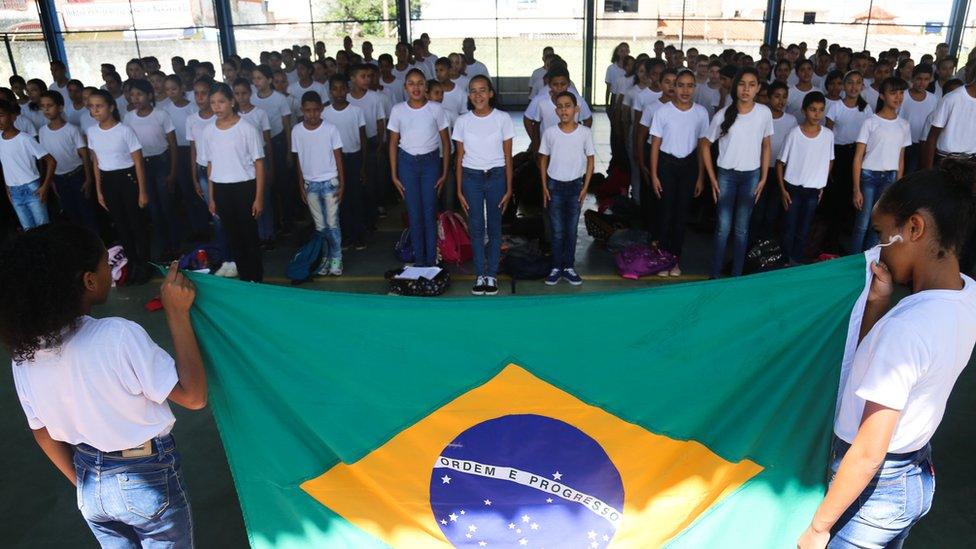 Brazilian students sing the national anthem