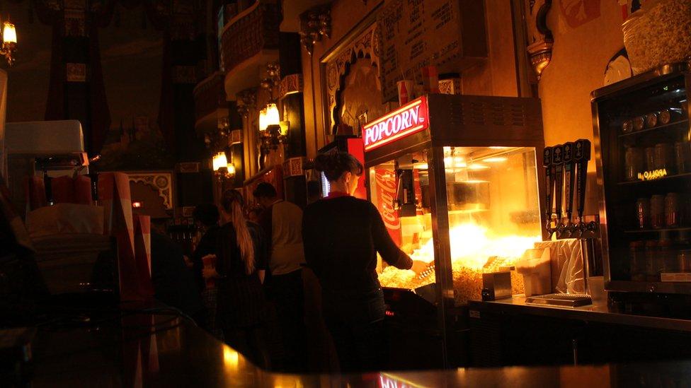 Staff get popcorn and refreshments inside a grande theatre