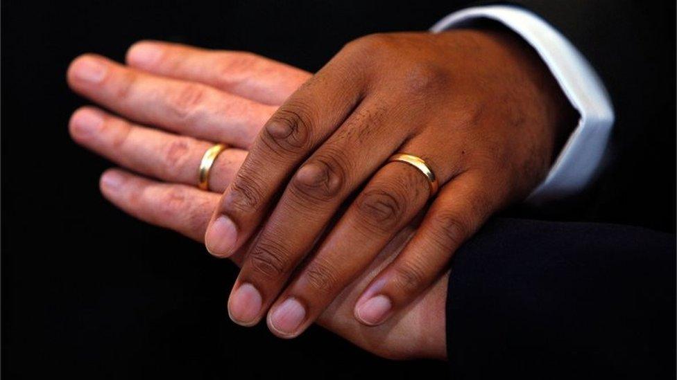 Men hold hands after wedding ceremony