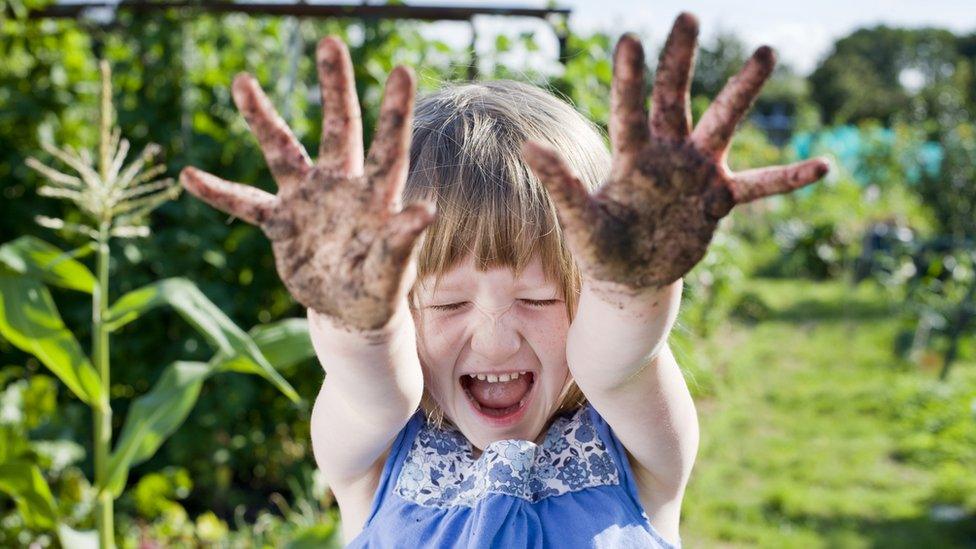 Girl with mud on her hands