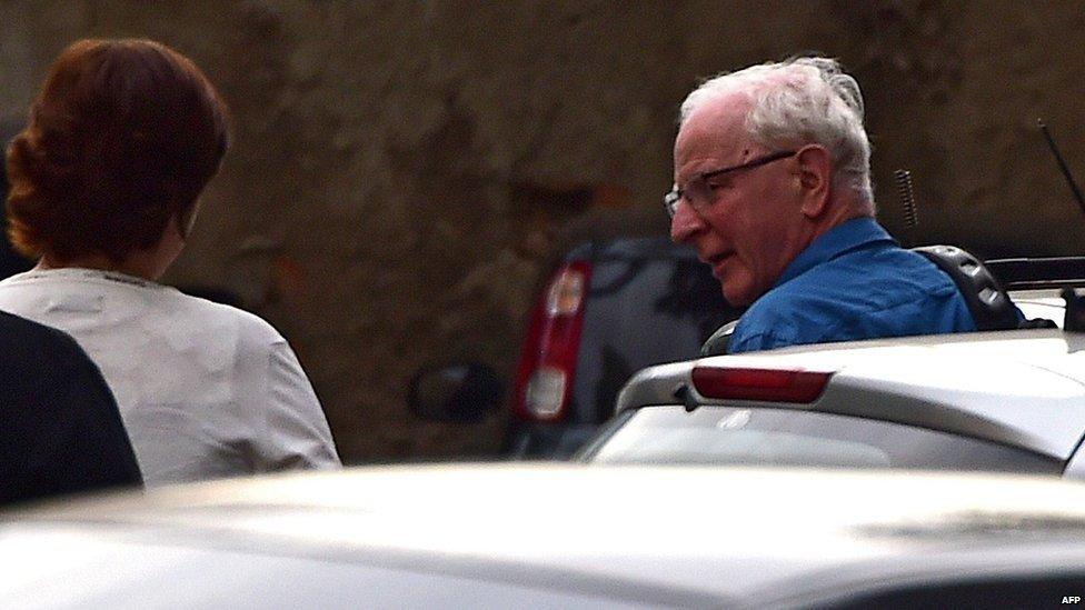 Pat Hickey (R) arrives at a police station in Rio de Janeiro, Brazil, 18 August