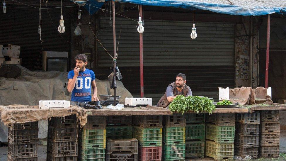 Syrians sell a few items at a market in the rebel-held area of the northern Syrian city of Aleppo on September 19, 2016, after humanitarian relief failed to enter the city under siege.