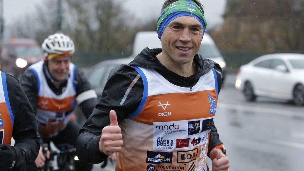 Kevin Sinfield shows a thumbs-up to members of the public as he crosses the Tyne Bridge and into Gateshead