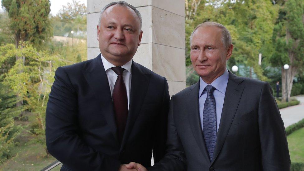 Russian President Vladimir Putin shakes hands with his Moldovan counterpart Igor Dodon on October 10, 2017