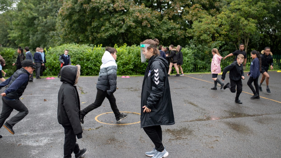 Children at schoo playing sports outside l in England during national lockdown