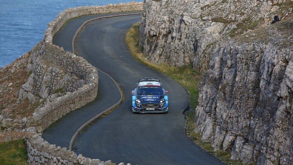 rally car driving along coast road