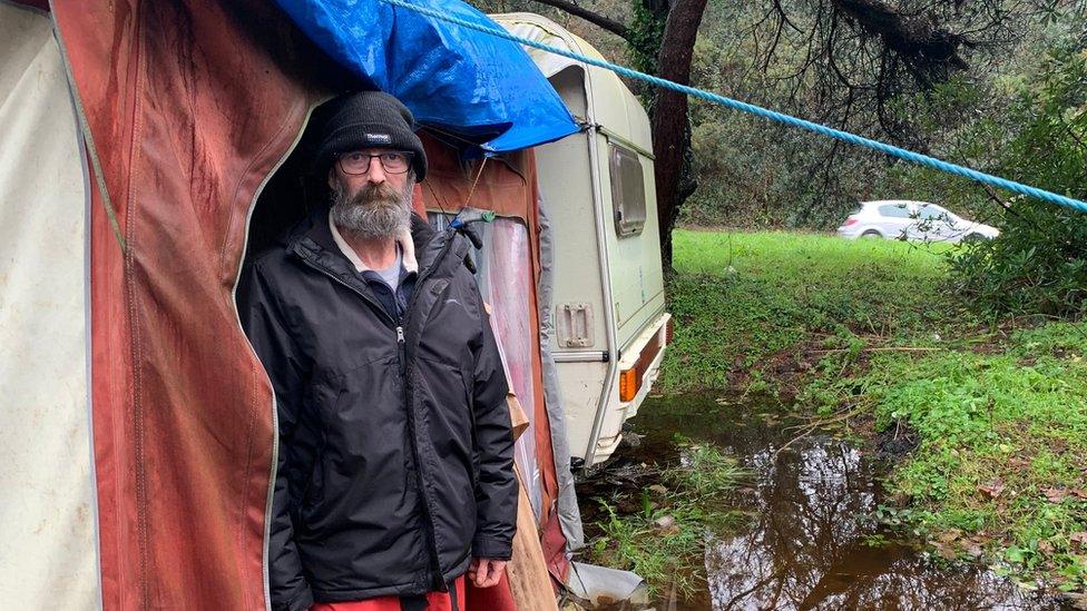 Man stood in front of a caravan