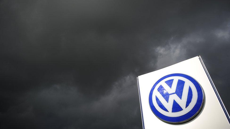 Volkswagen sign with storm clouds behind